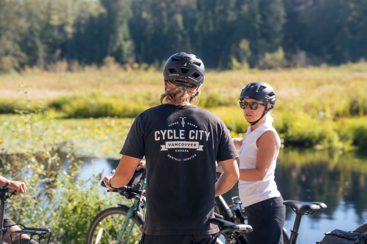 A Cycle City guide and a guest parked by Beaver Lake in Stanley Park.