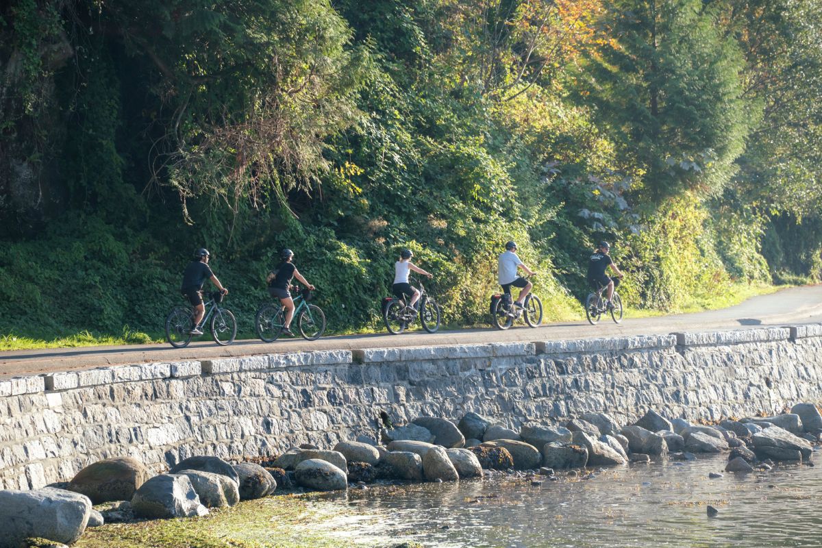 Five cyclists riding the Seawall on the Grand Bike Tour.