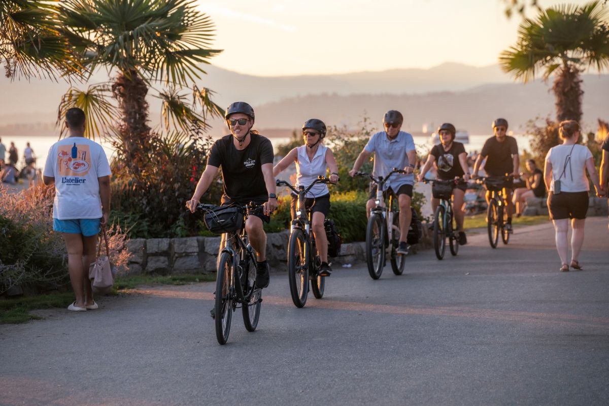 Three cyclists riding around Sunset Beach Park on a Cycle City guided bike tour.