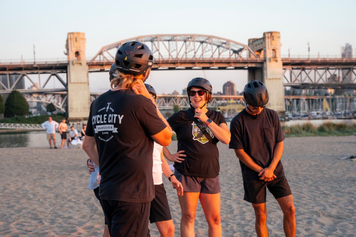 A bike tour group talking to each other nearby the Burrard Street Bridge on the Grand Bike Tour.