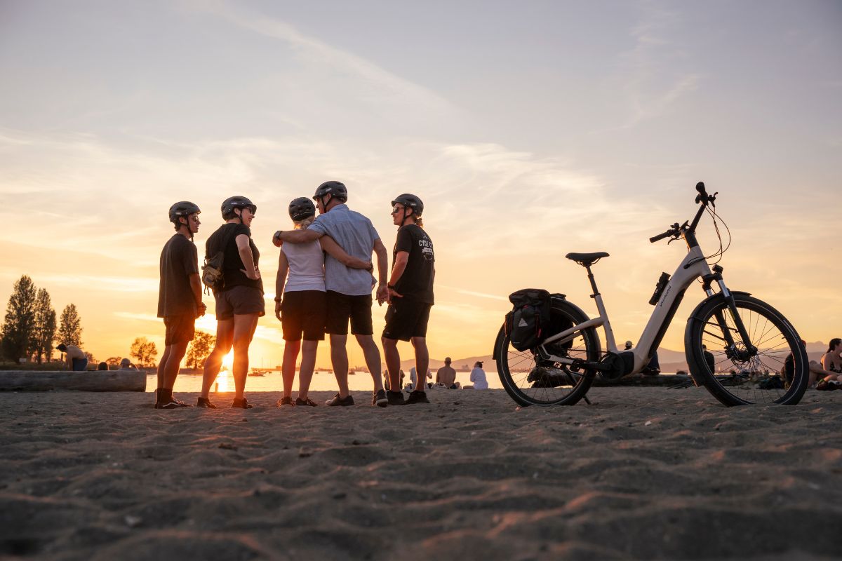 A bike tour group hanging out on Sunset Beach at sunset on the Epic Electric Bike Tour.