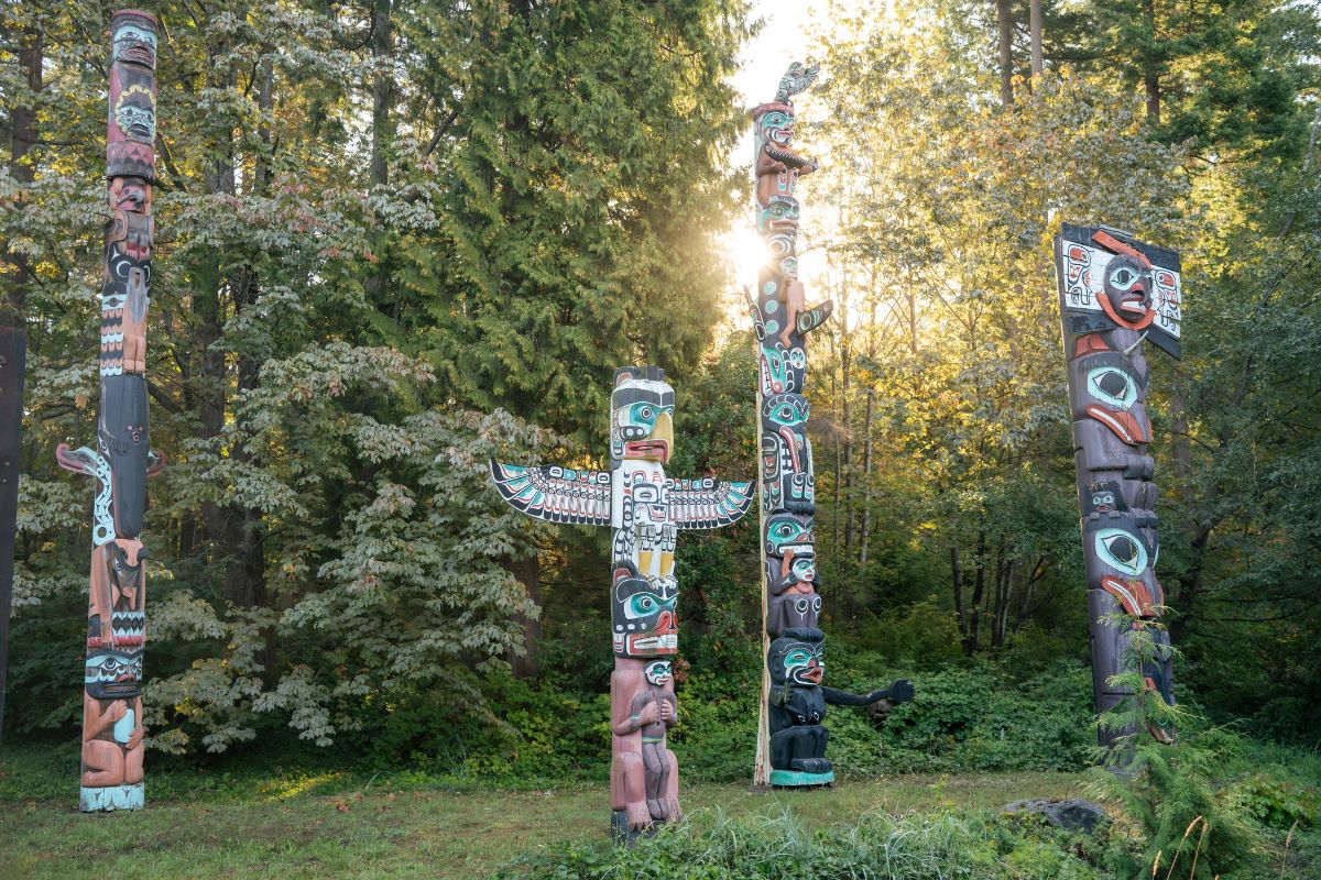 Four totem poles as seen in Stanley Park on a Cycle City guided bike tour.