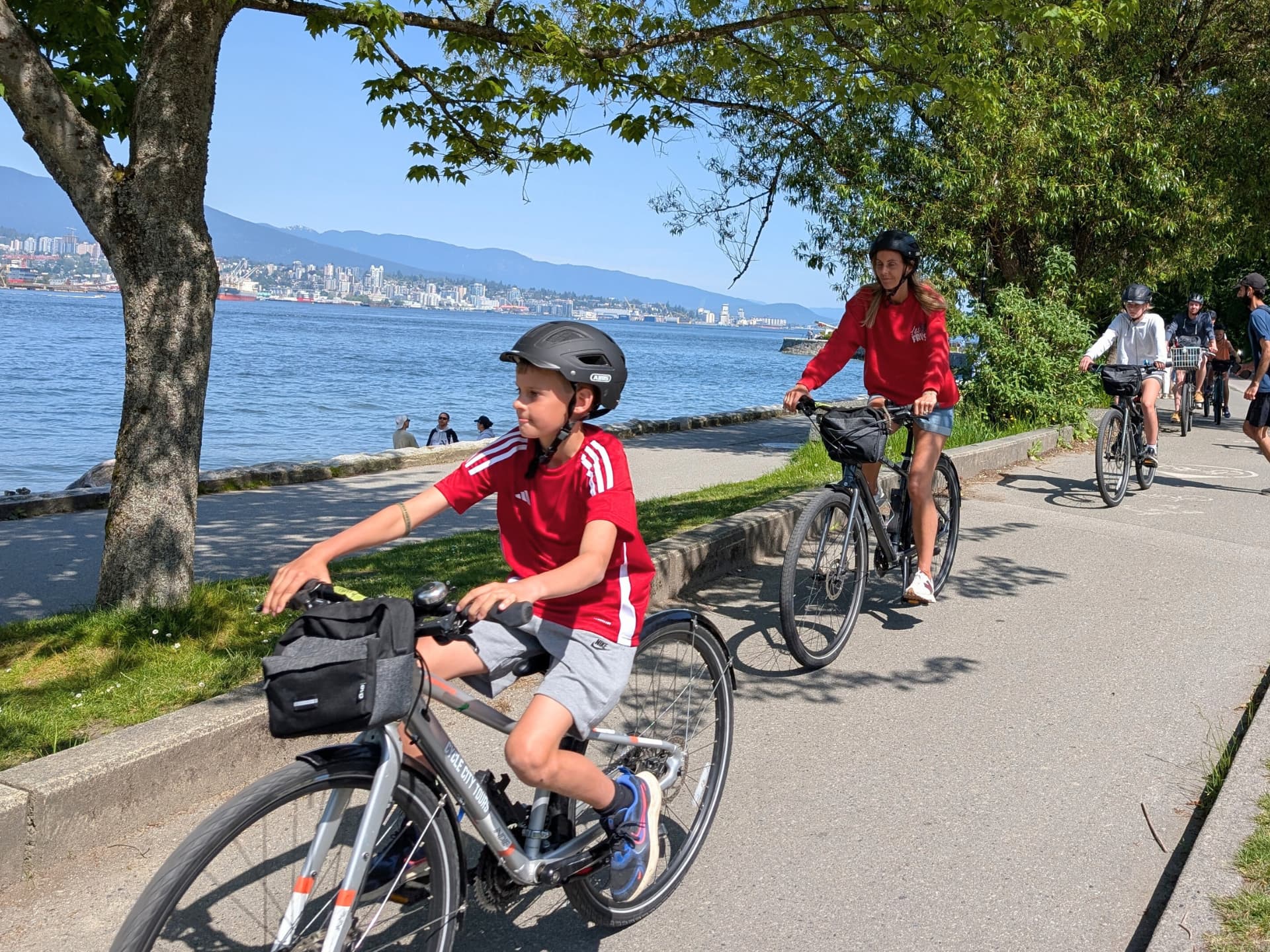 a family rides bike along the stanley park seawall