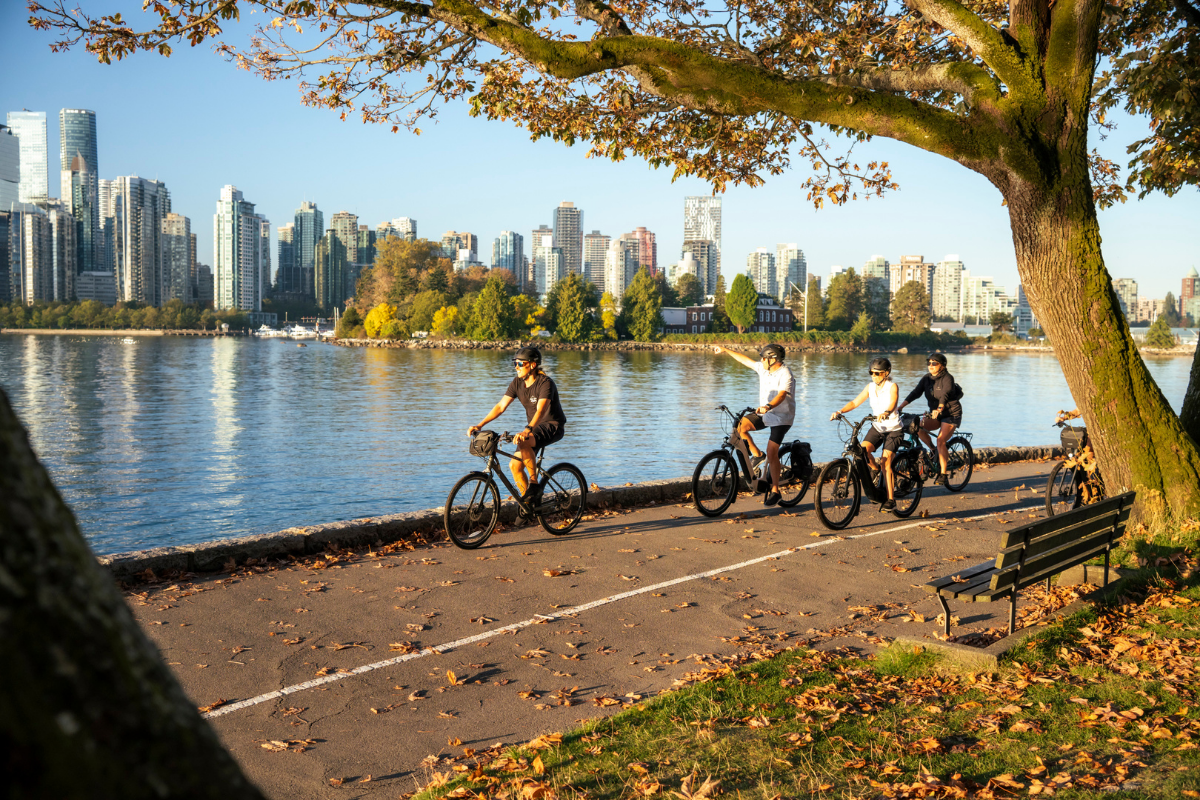Vancouver Cruise Layover Bike Rental: Your Self-Guided Half-Day Loop From Canada Place A group of cyclists riding along Vancouver’s Seawall with the downtown skyline in the background